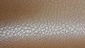 Shiny beige leather background close-up. Beige Glossy Texture Of Artificial Leather. Royalty Free Stock Photo