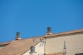 Background with spanish tiled roofs of houses against a cloudless blue sky