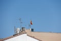 Background with spanish tiled roofs of houses against a cloudless blue sky