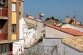 Background with spanish tiled roofs of houses against a cloudless blue sky