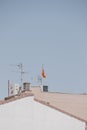 Background with spanish tiled roofs of houses against a cloudless blue sky