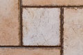 Background of square and rectangular beige and dark brown tiles. Smooth surface with uneven contrasting edges of the seams.Soft