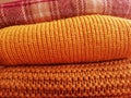 Background of a stack of knitted pink and orange sweaters