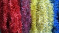 Background of striking palette of colorful shiny classic tinsel Garland. Red, yellow and blue color gradient. Winter accessories f Royalty Free Stock Photo