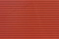 Background striped red metal profile. Texture of painted red metal surface.
