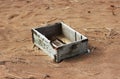 Background of summer beach with empty wooden ammunition box after high tide and low tide. Royalty Free Stock Photo