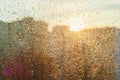 Background sunny window with shiny rain drops, view of the modern city.