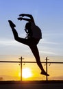 With the background of a sunset a dancer executes a jump Royalty Free Stock Photo