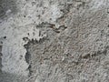 Background, surface texture. a layer of white peeling paint on rough gray concrete, cement, plastered wall. Royalty Free Stock Photo