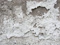 Background, surface texture. a layer of white peeling paint on rough gray concrete, cement, plastered wall. Royalty Free Stock Photo