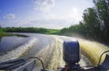 Foam and spray on surface of water behind a high-speed motor boat