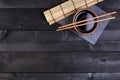 Background for sushi. Bamboo mat, soy sauce, chopsticks on dark table