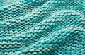 The background of the taken product is close-up in blue or turquoise color with waves and folds. Knitted fabric fabric Royalty Free Stock Photo