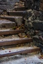 Background or texture of broken old, concrete steps on street with metal crossbars and fallen autumn, yellow leaves. Stone wall. Royalty Free Stock Photo