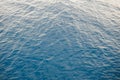 Background texture of a calm deep blue ocean with ripples on the surface of the seawater, full frame