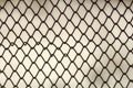 Background and texture for design. Abstract chain link fence texture against grungy gray color wall. Royalty Free Stock Photo