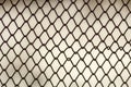 Background and texture for design. Abstract chain link fence texture against grungy gray color wall. Royalty Free Stock Photo