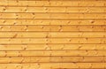 Background texture of finely slatted natural brown pine wood on the new house facade wall