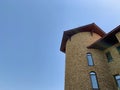 Background texture: fortress wall with a tower. Part of the castle against the blue sky. Wall of an old building Royalty Free Stock Photo