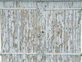 Background texture gray broken paint on old garage wooden door with a lock
