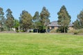 Background texture of gum trees and green grass lawn in a local park with some Australian suburban residential houses