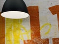 Background texture: lamp on a background of yellow-orange wall. Spotlight on a painted brick wall. Concept: interior lighting, Royalty Free Stock Photo