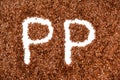 Background texture made of of brown flax seeds with a white letters P