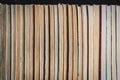 Rows of old pocketbooks on the book shelf in library.