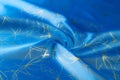 Background texture, pattern. Fabric blue silk with gold pattern. Royalty Free Stock Photo