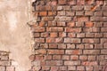 Background texture red old brick crumbling wall with a piece of crumbling plaster Royalty Free Stock Photo