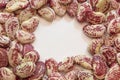 Background texture of red speckled October beans in an open circle, creative copy space