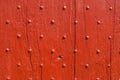 Background texture weathered red wooden door with nail decoration