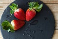 Background with three big strawberries on black slate board Royalty Free Stock Photo