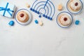 Background with traditional donuts, menorah and gift box. Hanukkah holiday concept. Top view, flat lay