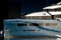 Background urban photo of a modern luxurious super yacht anchored in a big city port at sunset Royalty Free Stock Photo