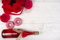 background for Valentine\'s day with a bottle of champagne, heart, red roses, donuts on a wooden Royalty Free Stock Photo