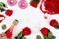 background for Valentine\'s day with a bottle of champagne, heart, red roses, donuts on a wooden Royalty Free Stock Photo