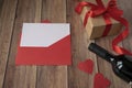 Background for Valentine`s Day. A bottle of wine, a gift from kraft paper, a red envelope, a heart and a satin red ribbon on a woo Royalty Free Stock Photo