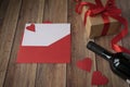 Background for Valentine`s Day. A bottle of wine, a gift from kraft paper, a red envelope, a heart and a satin red ribbon on a woo Royalty Free Stock Photo