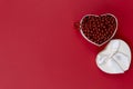 Background of Valentine`s Day. On a red background on the right is an open white gift box with red beads. Royalty Free Stock Photo