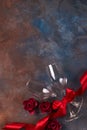 Background of Valentines day celebration with two glasses, roses and red ribbon on stone background with copy space Royalty Free Stock Photo