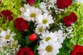 Background with a variety of fresh flowers. Bouquet of red roses, white daisies, greenery and wildflowers. Royalty Free Stock Photo