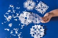 Background of various Christmas themed snowflakes cut out of white paper on a trendy blue background 2020 with a gift Royalty Free Stock Photo