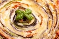 Background of Vegetable Spiral tart with zucchini, eggplant, carrot with a sprig of basil, close up macro shoot