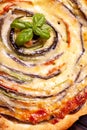 Background of Vegetable Spiral tart with zucchini, eggplant, carrot with a sprig of basil, close up macro shoot