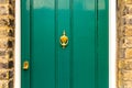 Background of vintage green painted door and knocker vignette look made of old fashioned vintage brass metal Royalty Free Stock Photo