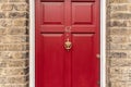 Background of vintage red painted door and knocker vignette look made of old fashioned vintage brass metal Royalty Free Stock Photo