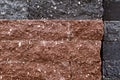 Background, a wall of brown and black facing bricks with a relief texture. Royalty Free Stock Photo