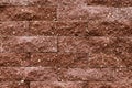 Background, a wall of brown facing bricks with a relief texture. Royalty Free Stock Photo