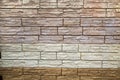 The background of the wall is made of artificial stone of elongated irregular shape in white, beige and gray colors. Backgrounds Royalty Free Stock Photo